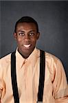 Cute young African-American adult with suspenders smiles