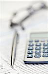 Piece of paper, pen, glasses and pocket calculator on a white background