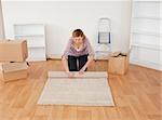 Blonde Frau einen Teppich aufrollen, Haus verschieben vorzubereiten