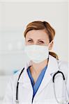 Blond-haired scientist with a mask and a stethoscope posing in a lab