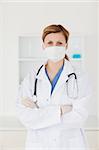 Blond-haired scientist with a mask and a stethoscope looking at the camera while posing in a lab