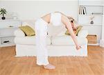 Good looking blonde woman stretching in the living room in her appartment