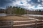 A field with a wooden fence in the foreground