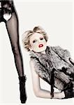 Blond fashion model in fur and red lipstick  , black fishnet stockings and high-heels
