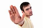 young man with his hand raised in signal to stop, isolated on white background, Studio shot