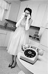 Young Caucasian woman weeps near a phone in a retro-style kitchen scene