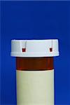 Medicine bottle with yellow label isolated on blue background.  Your text can be on the yellow label.