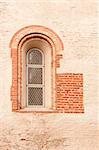 the antique window in stone wall with red bricks