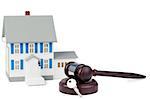 Grey toy house model with a key and a brown gavel against a white background