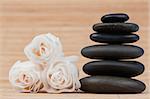 Close up roses and a black pebbles stack against bamboo background