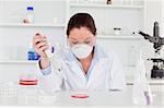 Young scientist preparing a sample while wearing a protective mask