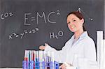 Cute scientist showing the equations on a blackboard