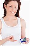 Young woman looking at the camera while testing her blood