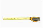 Yellow measuring tape partly unrolled against a white background