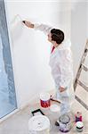 High angle view of workman painting the wall with a roller