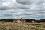 Sommerhouse and Danish flag out the dunes a summer day.