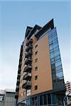 Angular Apartment Block built of brick and glass against a ble sky