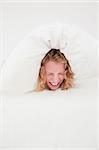 Attractive blonde female balled-up in a duvet in her bedroom in her appartment