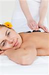 Portrait of a delighted woman having a hot stone massage in a spa