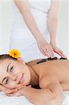 Portrait of a woman enjoying a hot stone massage in a spa