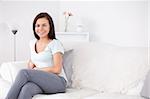 Young woman sitting on a sofa while looking at the camera