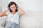Cute brunette listening to music in her living room