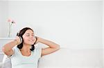 Delighted brunette listening to music in her living room