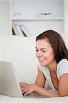 Portrait of a young woman on a sofa using a laptop in her living room