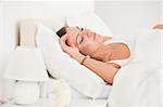 Young brunette sleeping in her bed against a white background