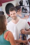 Young handsome Caucasian man flirts with woman in laundromat