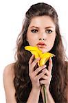 face shot of a young model with curly long hair holding a yellow calla