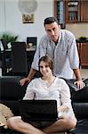 joyful couple relax and work on laptop computer at modern home