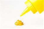 A yellow mustard bottle against a white background