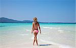 Young woman walking at a tropical turquoise beach