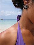close-up of starfish earing being worn by asian female on beach with sea over her shoulder on koh tao in the gulf of thailand