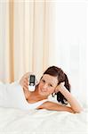 Cute woman showing mobile in the bedroom