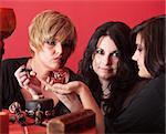 Witch coven over red background with magic potion