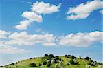 Landscape with hill, blue sky and clouds.