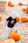 cute caucasian toddler on the pumpkin patch