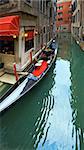 Venetian view with parked luxurious gondola on canal (Venice, Italy)