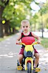 happy children in park ride cycle at park on summer season