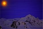 Moon on the dark blue sky among mountains. Antarctica.