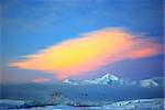 Covered with white snow mountain covered with clouds at sunset in Antarctica