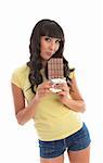 A beautful girl eating from a lblock of decadent chocolate.  White background