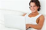 Smiling man using a notebook in his bedroom