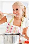 Portrait of a blonde woman tasting her meal while looking away from the camera