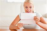 Woman looking at a letter in amazement in her living room