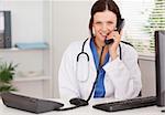 A female doctor is telephoning in an office
