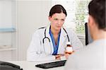 A female doctor and a patient with pills sitting in an office