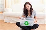 Cute woman with a recycling box in a living room
